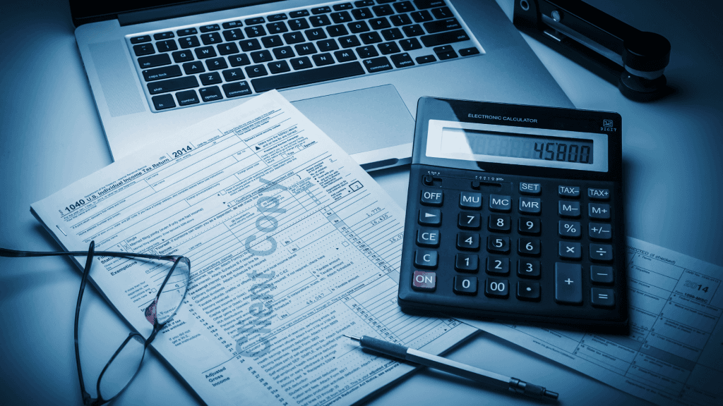 Tax forms, calculator and laptop